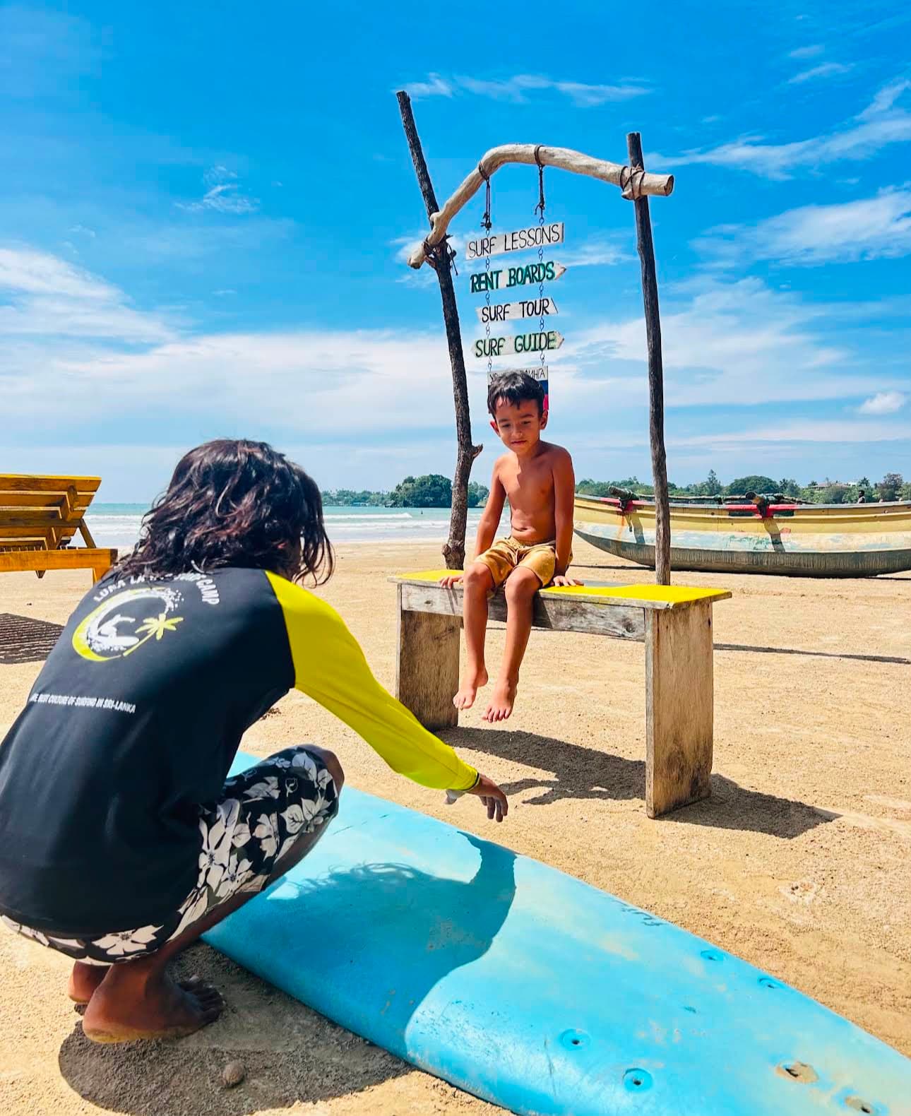 A Luna Lanka instructor preparing a child for a surf lesson on the beach